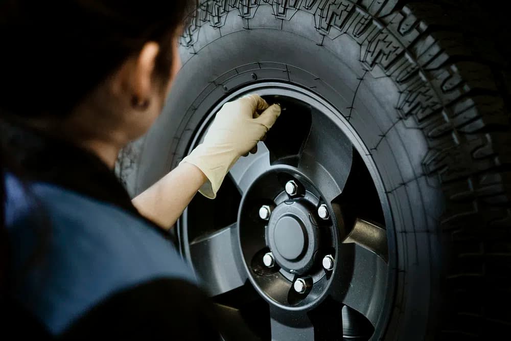 Femme qui monte un pneu dans un garage